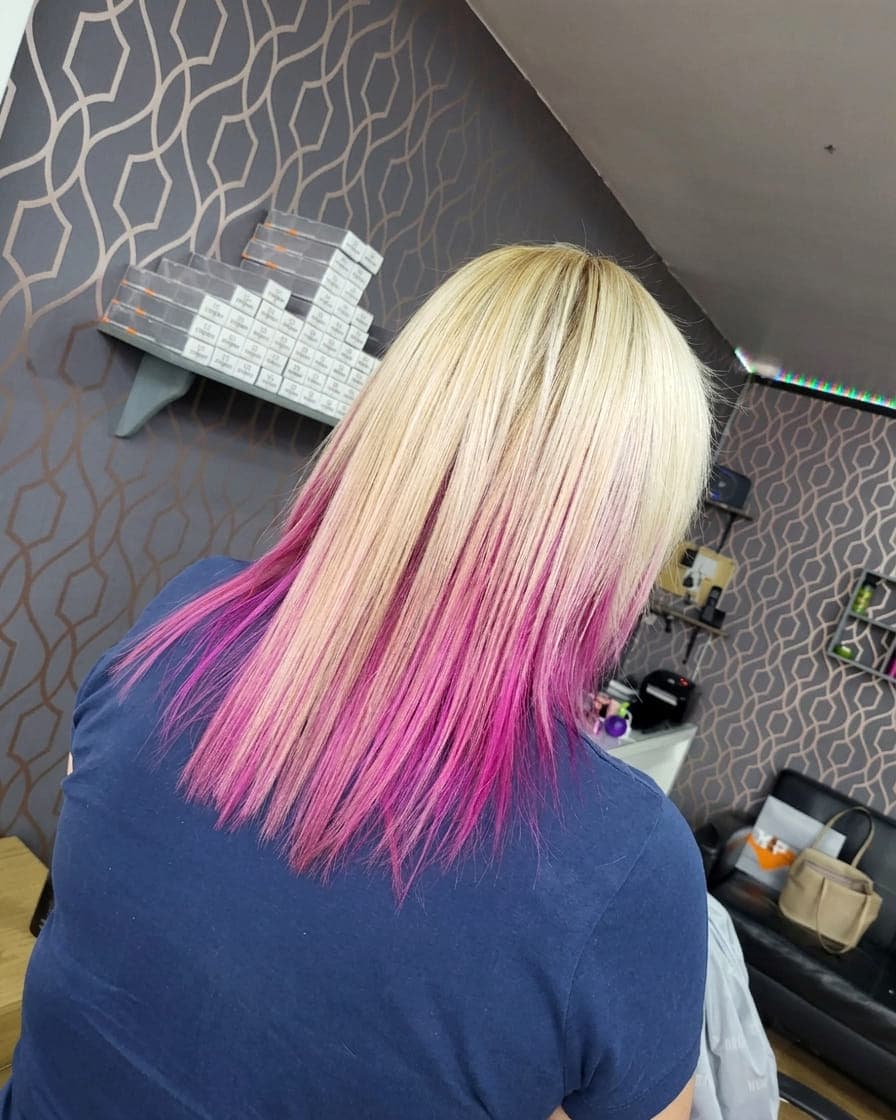 Blonde hair with a bright pink ombré blended through the mid-lengths and ends